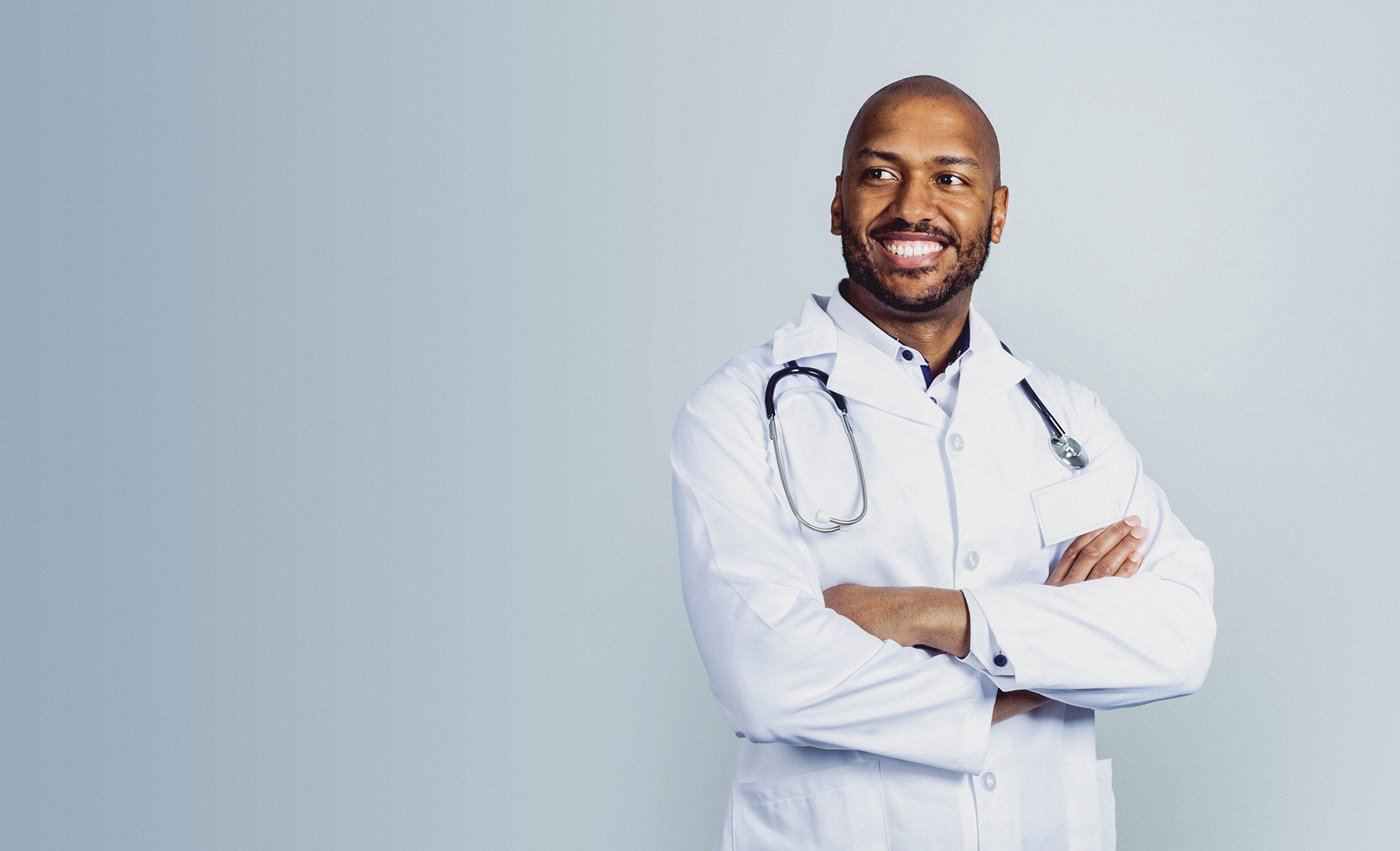 Doctor smiling in front of blue background