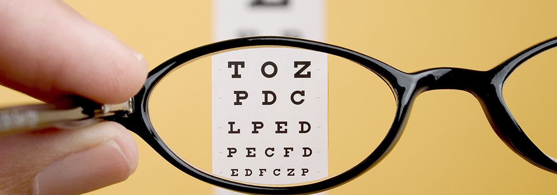 looking through a pair of glasses at an eye exam chart