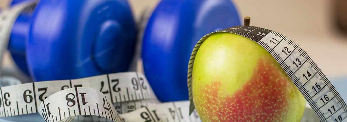 Apple, measuring tape, and dumbell