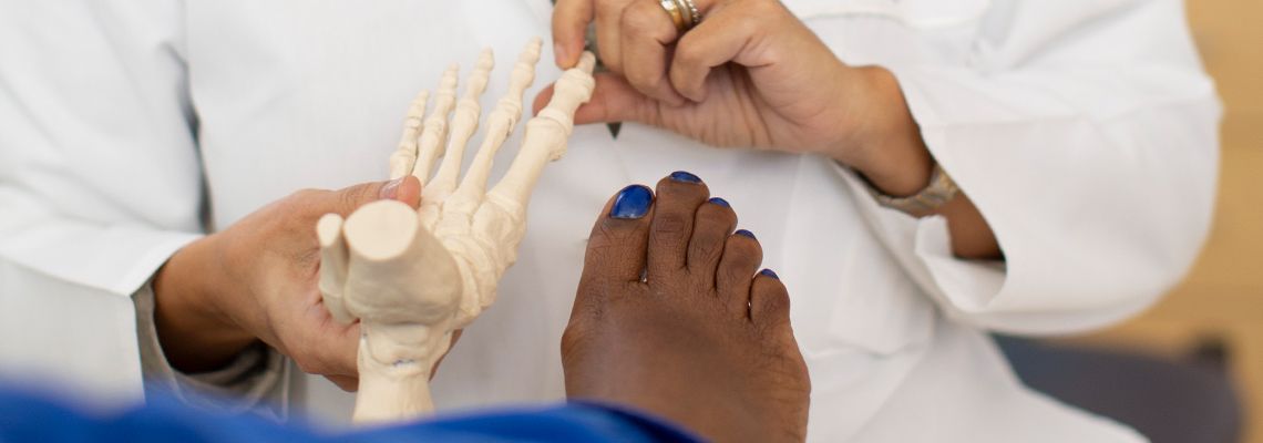 Doctor showing a patient a foot model