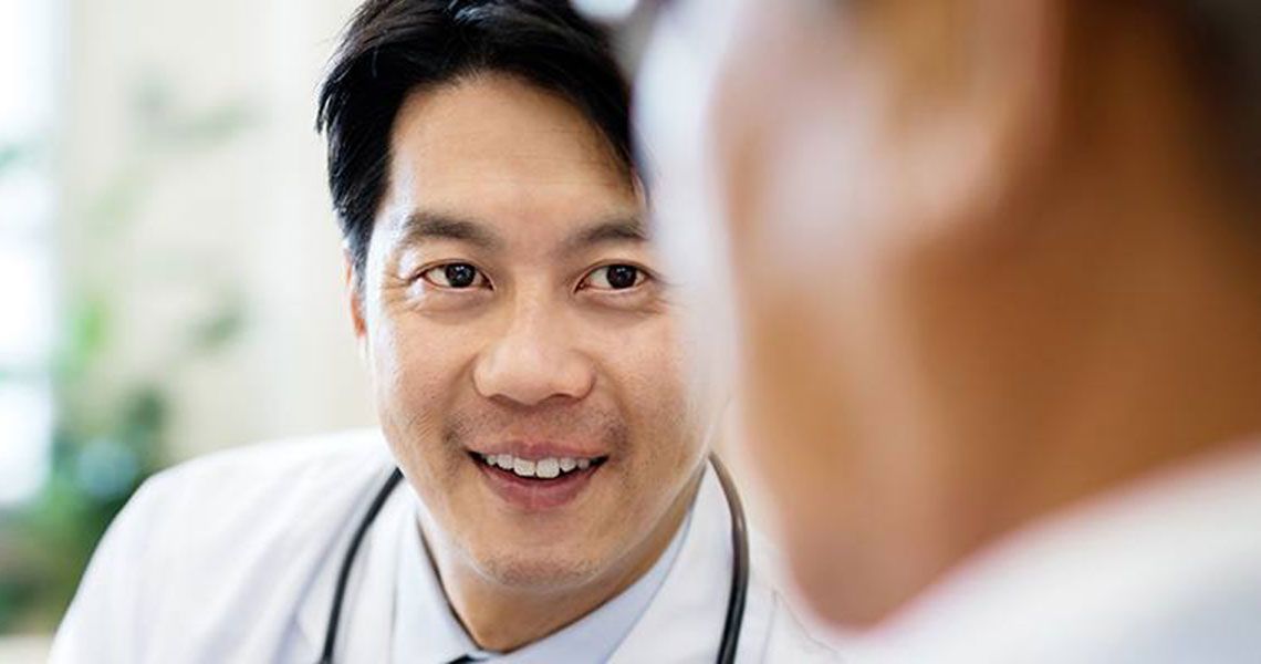 A doctor smiling and looking at a patient