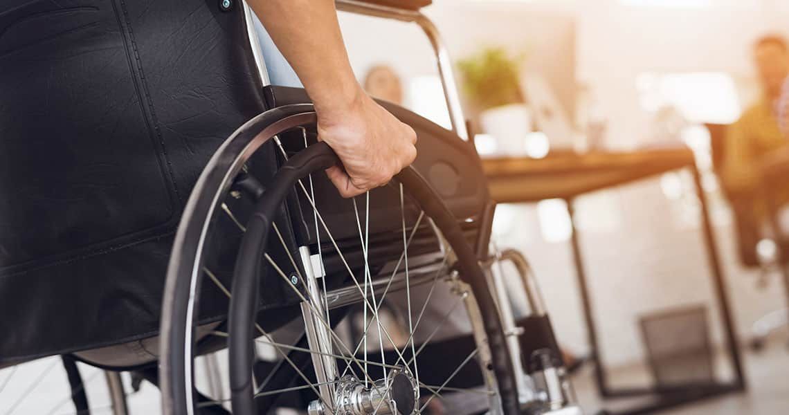A patient gripping their wheelchair