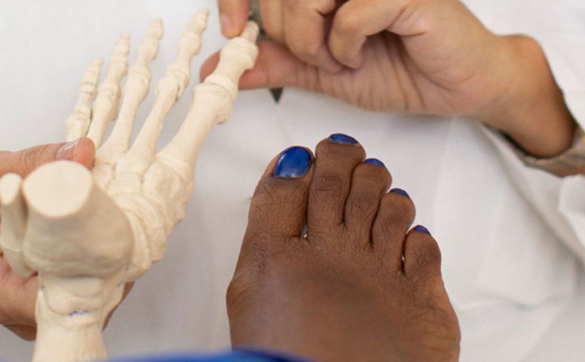 podiatrist showing patient bones of a foot