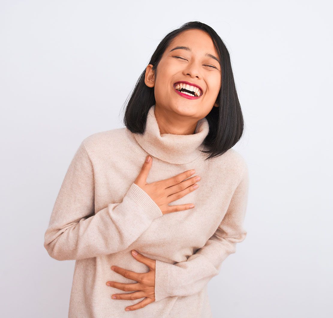 person laughing and holding her chest and belly