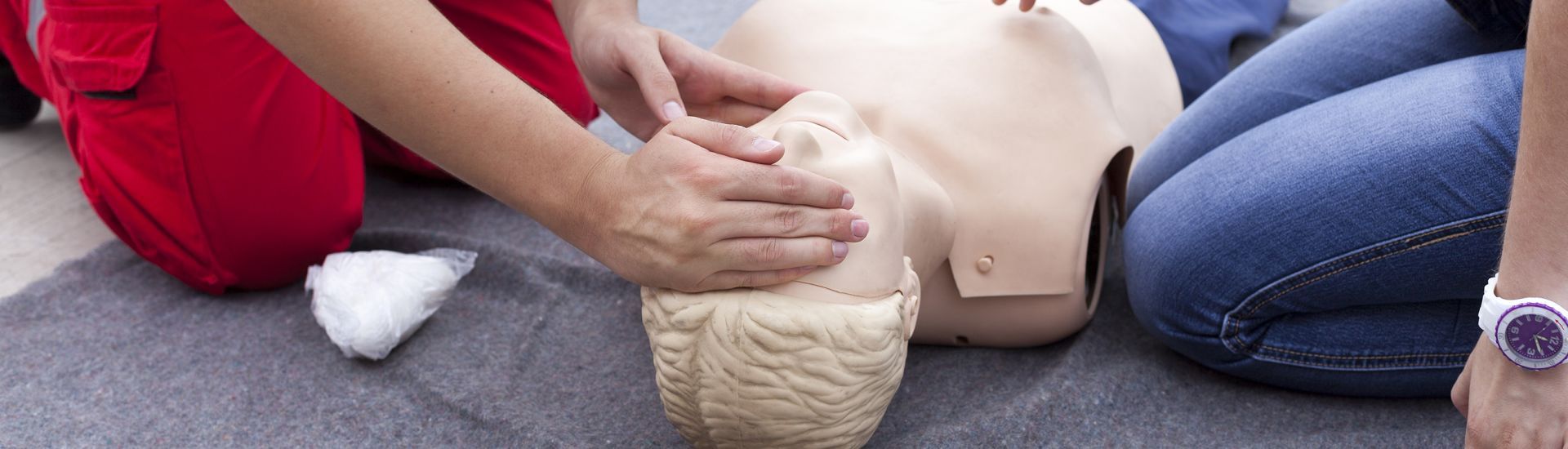person practicing CPR on a dummy