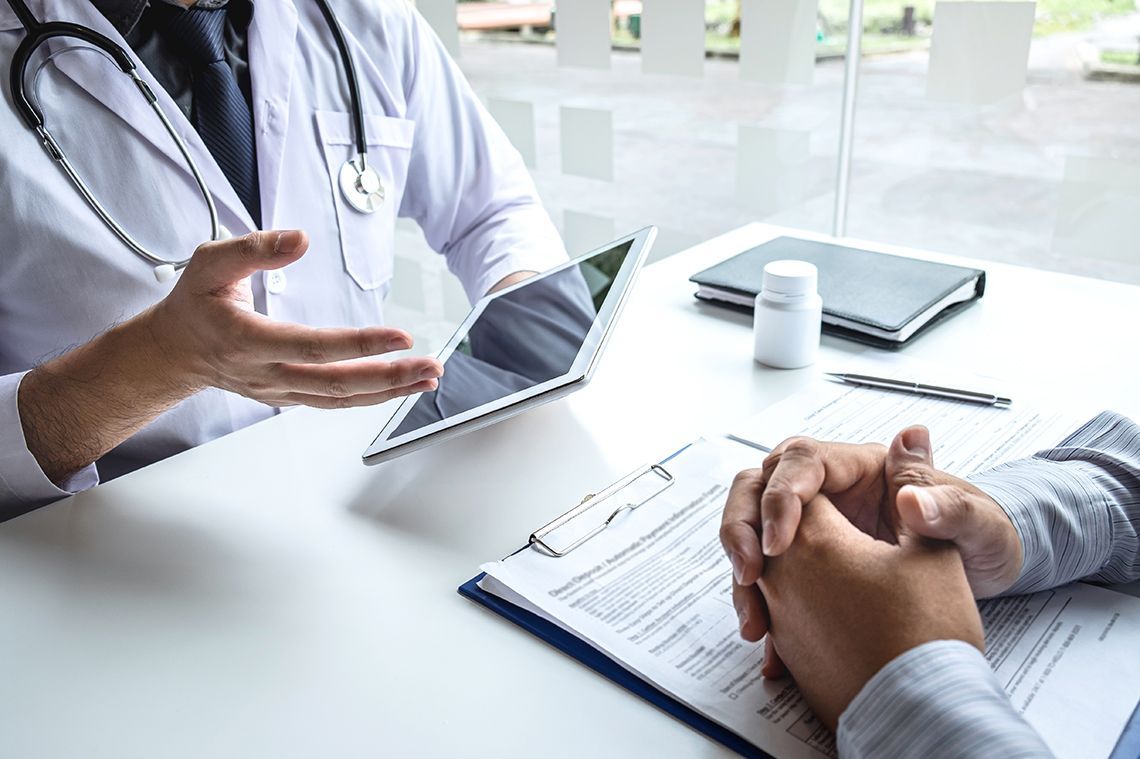 doctor talking to patient across a desk