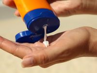 Sunscreen being squeezed into someone's hand